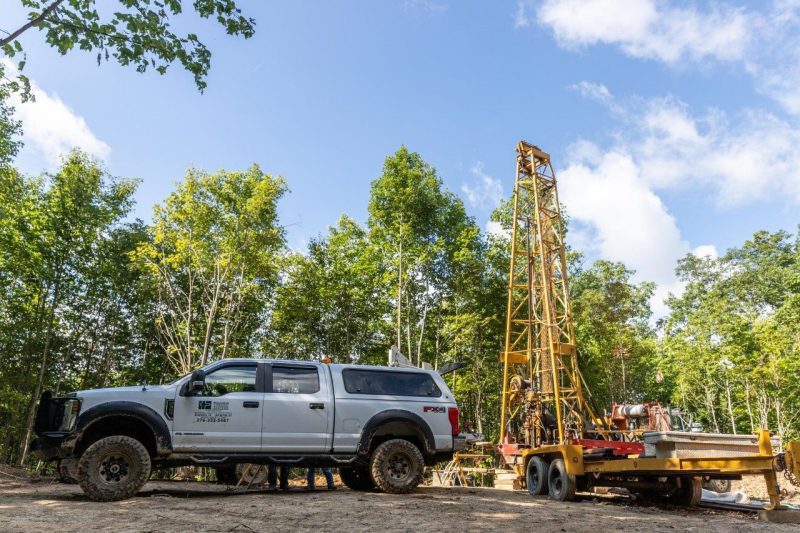 Truck in front of large drill looking for critical minerals